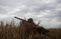 Hunter with a gun hiding in the field in Nord Trøndelag (Photo: Ove Martin)